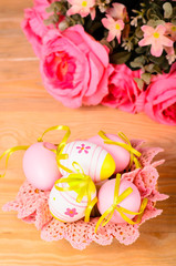 Easter decorative eggs and bouquet of pink flowers