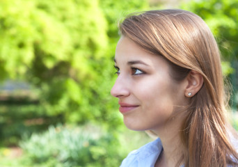 Junge Frau im Park blickt zur Seite