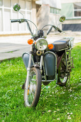A moped-style e-bike parked on the grass