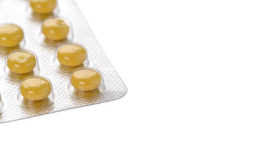 Yellow pills in blisters on white background