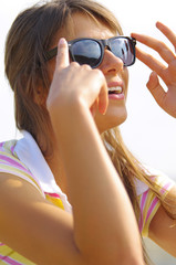 Young woman sitting in the sunlight with black sun glasses