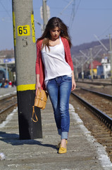 Young beautiful woman walking on trainstation - obrazy, fototapety, plakaty