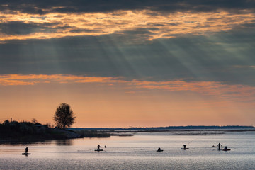Fishermen on sunrise on the lake