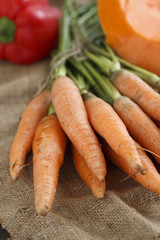 Fresh carrot with green tops and other vegetables