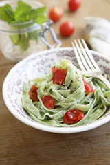 Spinach pasta with tomatoes, mint and goat cheese