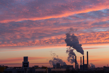 Winter scenic of power plant with a burning red clouds behind