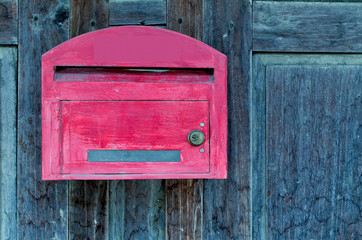 red wooden mail box on grunge wooden wall