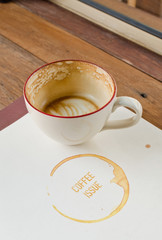 Coffee cup on book on wooden table