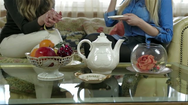 Elegant tea set on the table, female friends on the background
