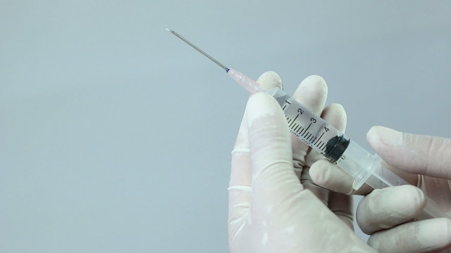 Nurse holds a syringe and prepares it for vaccination