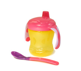 Yellow baby bottle with spoon a white background