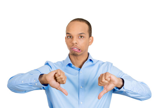 Displeased young man giving thumbs down gesture