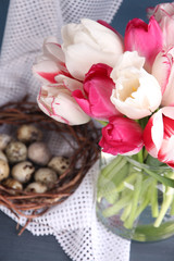 Composition with Easter eggs and beautiful tulips in glass jug