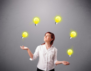 young lady standing and juggling with light bulbs