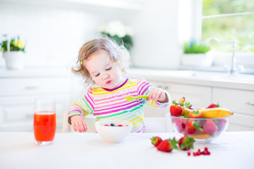 Little toddler girl having fruit for breakfast