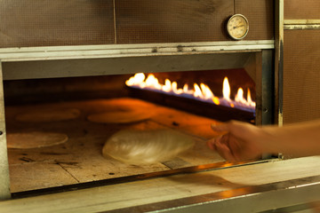 Detail of fresh traditionally baked bread pita into oven