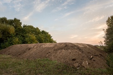 Large pile of soil under blue sky