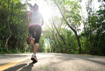 fitness woman running at forest road 