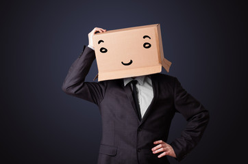 Businessman gesturing with a cardboard box on his head with smil