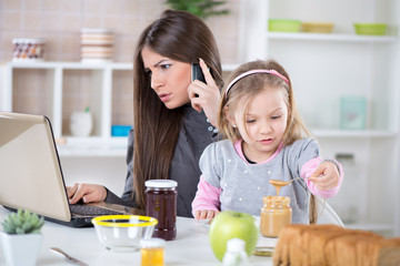 Overworked Businesswoman and her daughter in the morning.