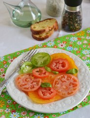 Tomato salad with oil, pepper, salt in a white plate