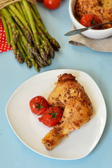 Roasted chicken leg with tomatoes and mustard on blue background