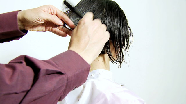 Professional hair stylist cutting hair short