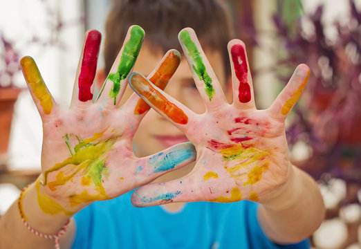 Niño con manos pintados de distintos colores