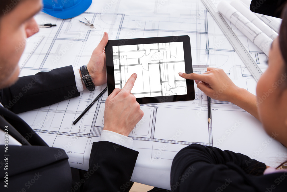 Poster architects with digital tablet working on blueprint