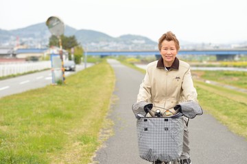 自転車に乗っている高齢者のアジア人女性