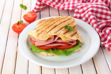 Tasty sandwich with ham on wooden table