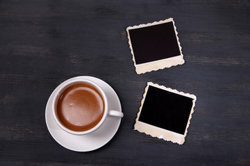 Coffee cup and old blank photos, on wooden background