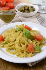 Delicious pasta with pesto on plate on table close-up