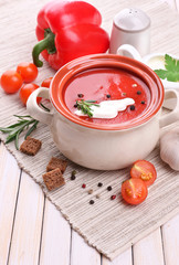 Tasty tomato soup and vegetables on wooden table