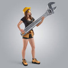 worker girl in a helmet holding a wrench