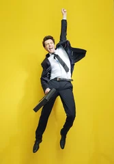 Poster Young succesful businessman in the victory jump © konradbak