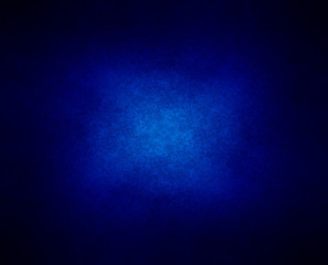 abstract blue background or dark paper with bright center spotli
