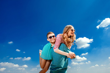 Happy couple embracing and having fun under the blue sky