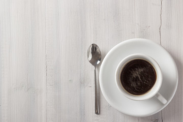 Cup of coffee from above on white wooden table