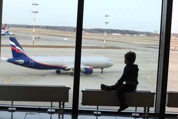 Kid looking at airplane