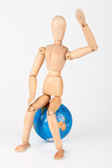 Wood mannequin sitting on top of a world globe to protect isolat