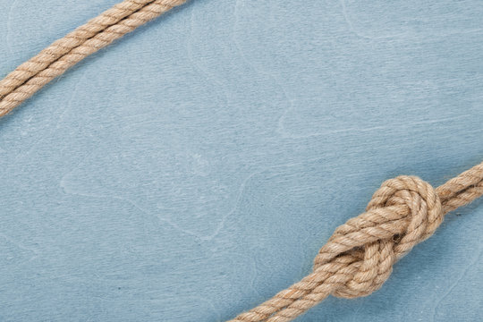 Ship rope knot on wooden texture background