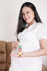 Beautiful hispanic pregnant woman having the word boy with woode