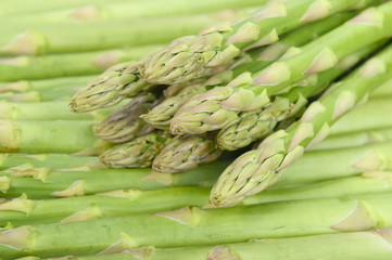 fresh green asparagus sprouts laying on bamboo background