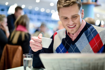 Man reading newspaper at outdoor cafe