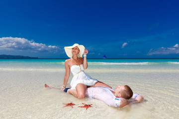 Bride and Groom on tropical beach shore with red starfish in the