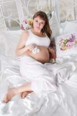 Beautiful pregnant woman with children's bootees