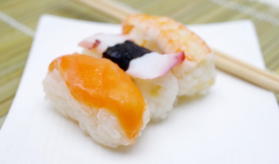 Sushi nigiri in with dish with bamboo sticks