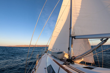 Sailboat crop during the regatta at sunset ocean - 64055488