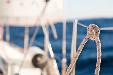 Afwasbaar Fotobehang Zeilen Knot on rope and sailboat crop in the sea